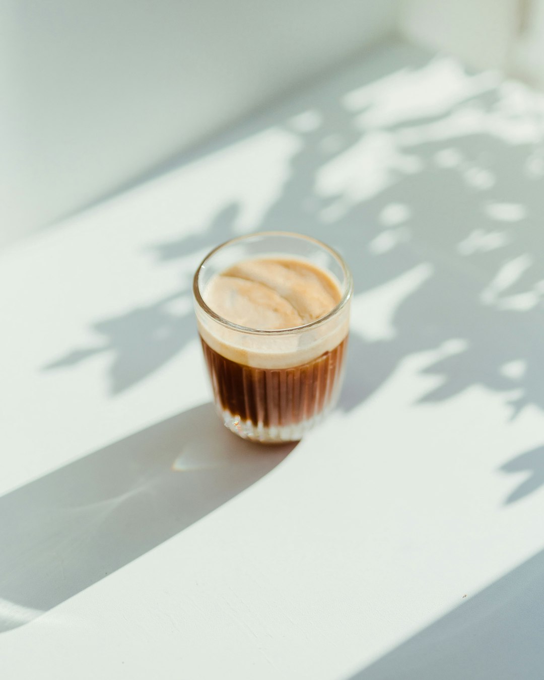 clear-drinking-glass-with-coffee-on-top-of-white-table-ihqdpfz7i8q